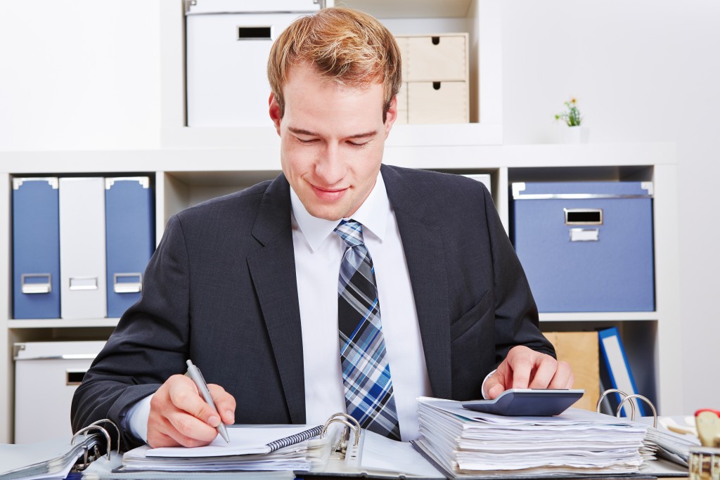 Accountant doing financing in the office using a calculator for a tax audit