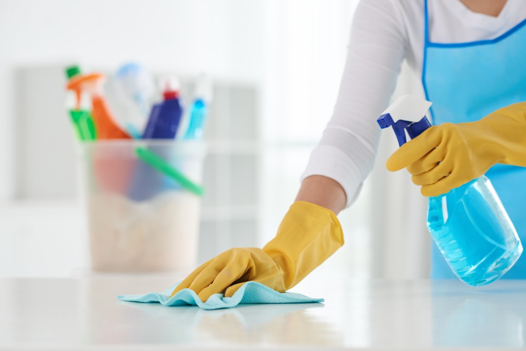 woman in gloves cleaning the kitchen