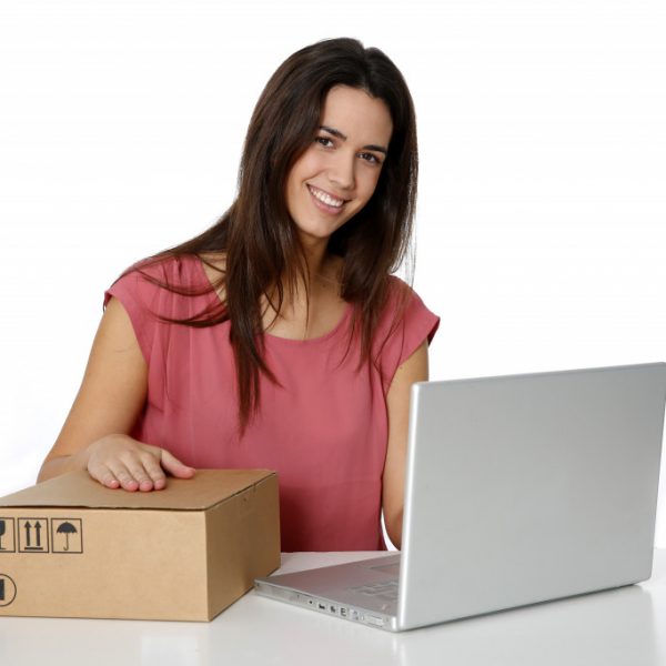 Young smiling woman preparing package to be sent by mail