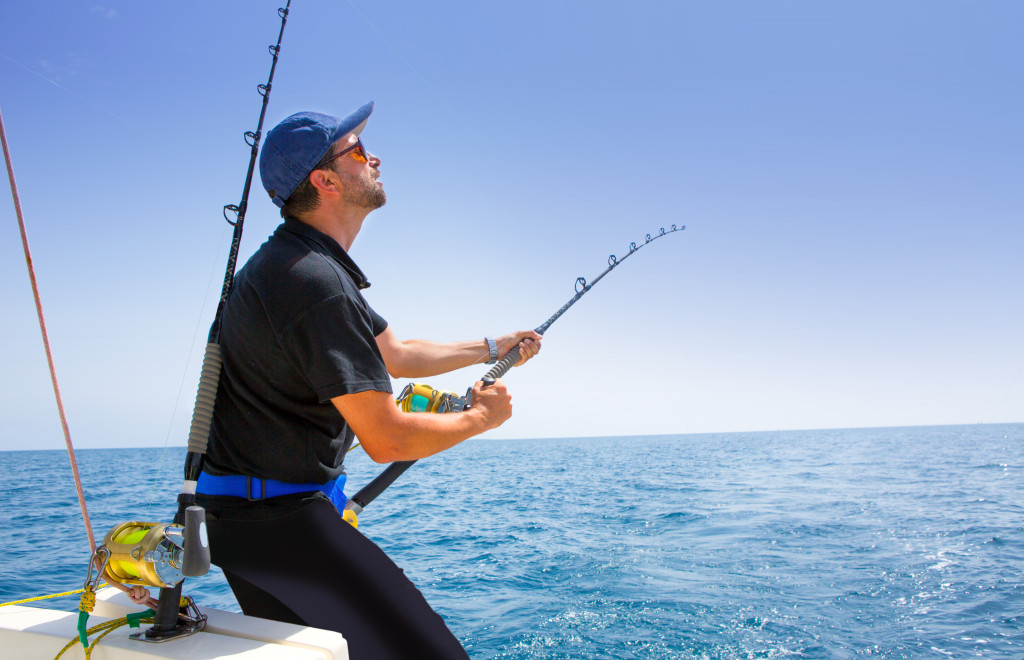 Blue sea offshore fishing boat with fisherman holding rod in action