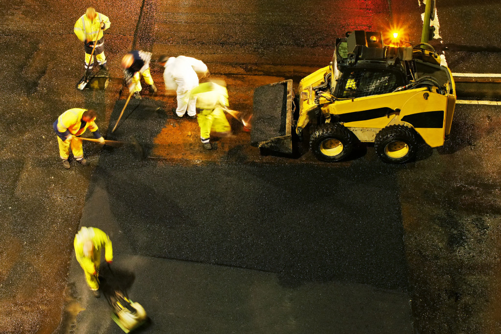 Construction workers working on a road at night
