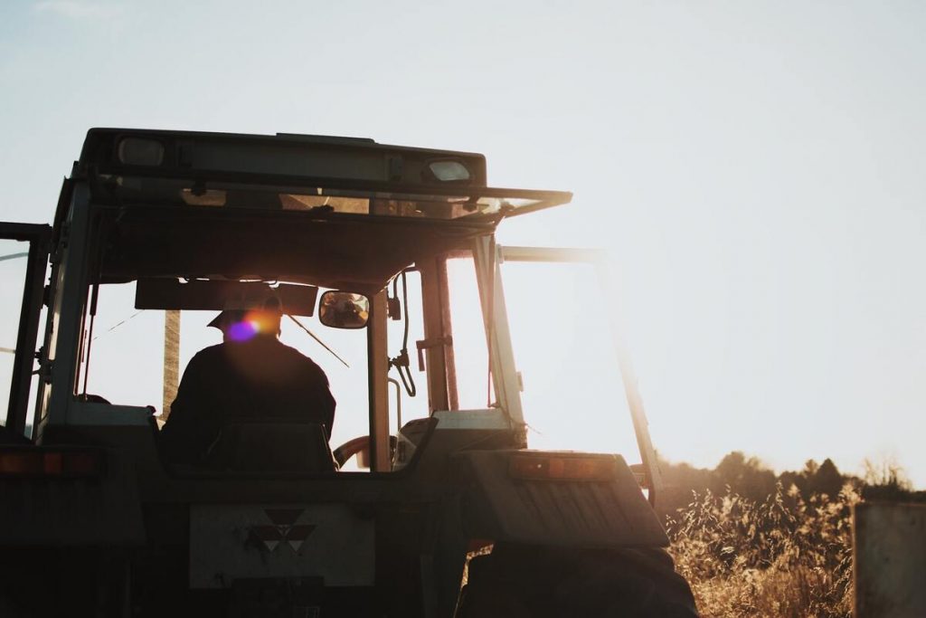silhouette of a farmer riding a tractor